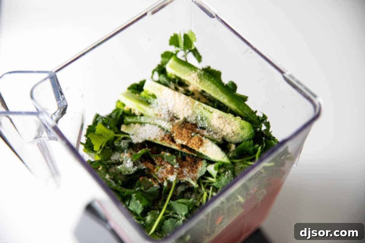 Jalapeños, cilantro, and spices ready to be blended into homemade salsa. Fresh jalapeños, vibrant cilantro, and a blend of aromatic spices visible in a blender, illustrating the key ingredients for the homemade salsa.