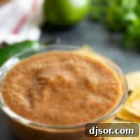 Homemade Salsa in a bowl with ingredients in the background, depicting a delicious and fresh dish.