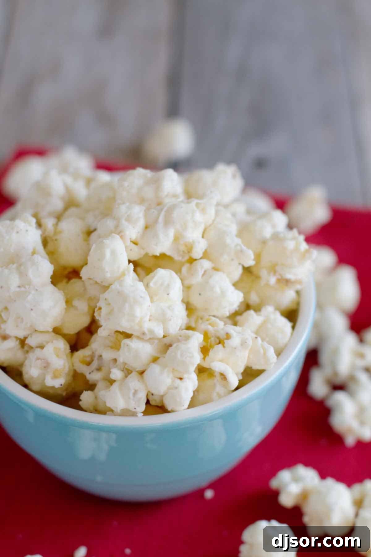 A vibrant blue bowl filled with festive Eggnog Popcorn, ready to be enjoyed.