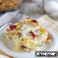 Benedict Brunch Bake 2 A beautifully presented slice of Eggs Benedict Casserole topped generously with creamy hollandaise sauce, ready to be enjoyed.