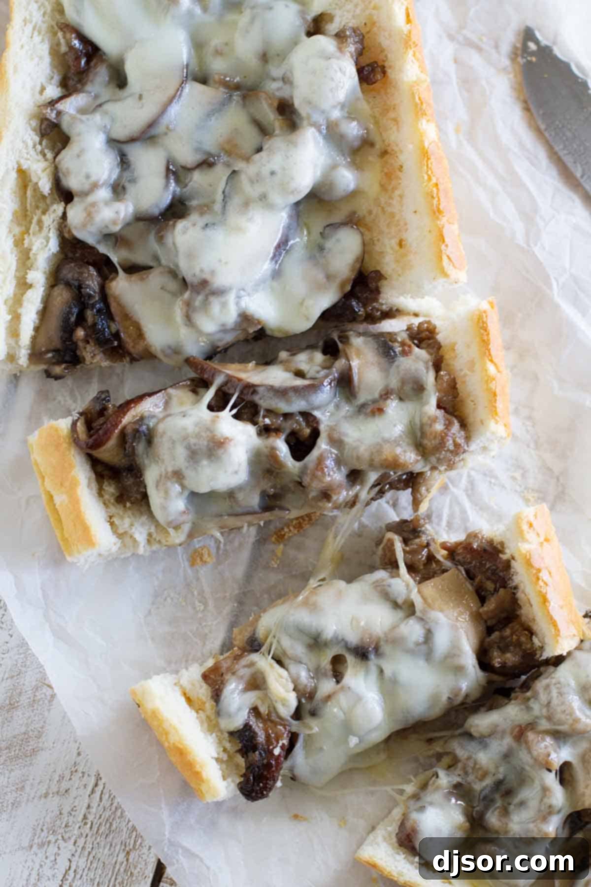 Gourmet Sausage and Portobello French Bread Pizza 4 Various slices of French Bread Pizza with Sausage and Portobello Mushrooms laid out, ready to be served.