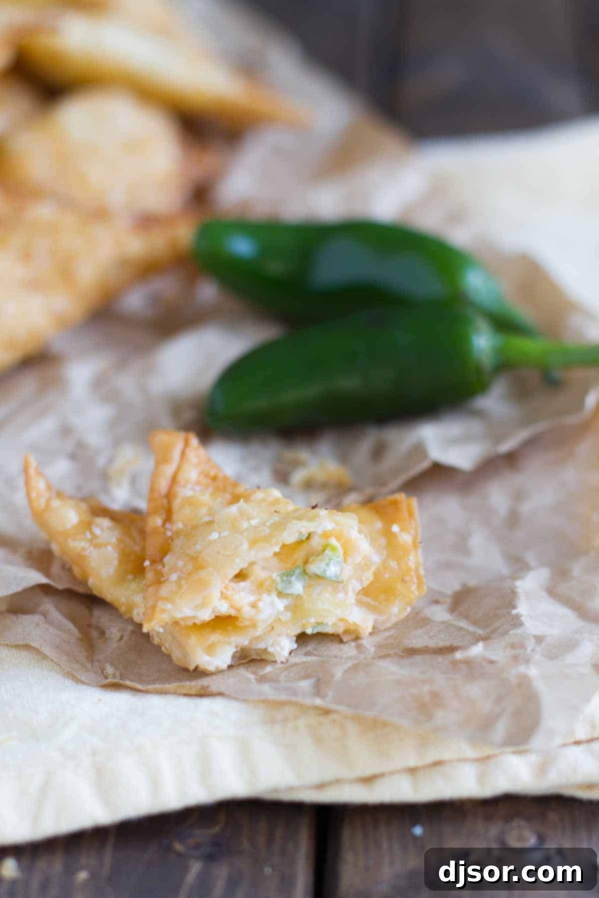These Jalapeno Popper Wontons are fried wontons that are stuffed with cream cheese and jalapeños in this tasty appetizer. Crispy Jalapeño Popper Wonton, broken open to reveal creamy, cheesy, and spicy filling.