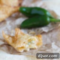 Spicy Cream Cheese Wonton Bites 2 Jalapeno Popper Wonton on paper opened up to show filling.