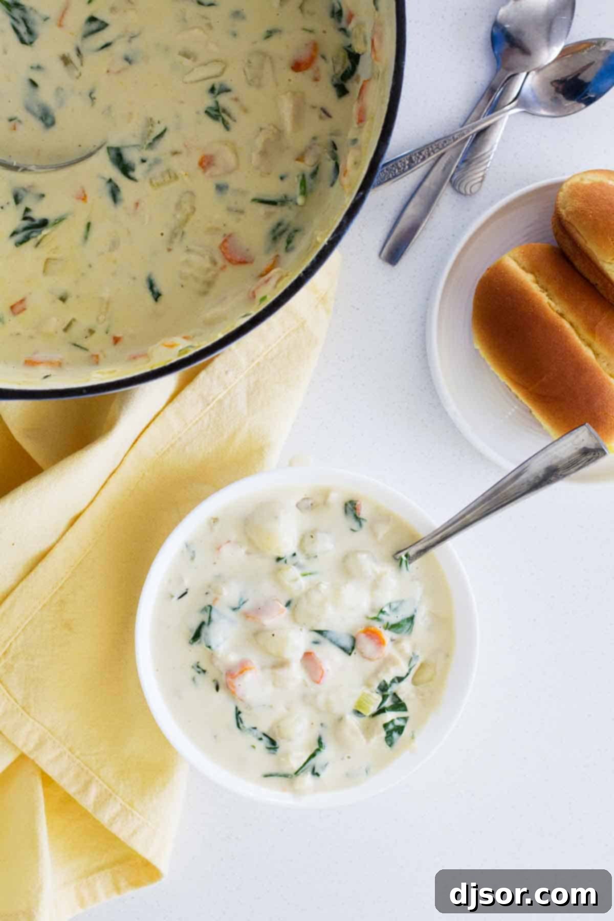 An overhead view of a hearty bowl of Chicken and Gnocchi Soup, showcasing its rich, creamy texture and comforting appeal, garnished with fresh herbs.