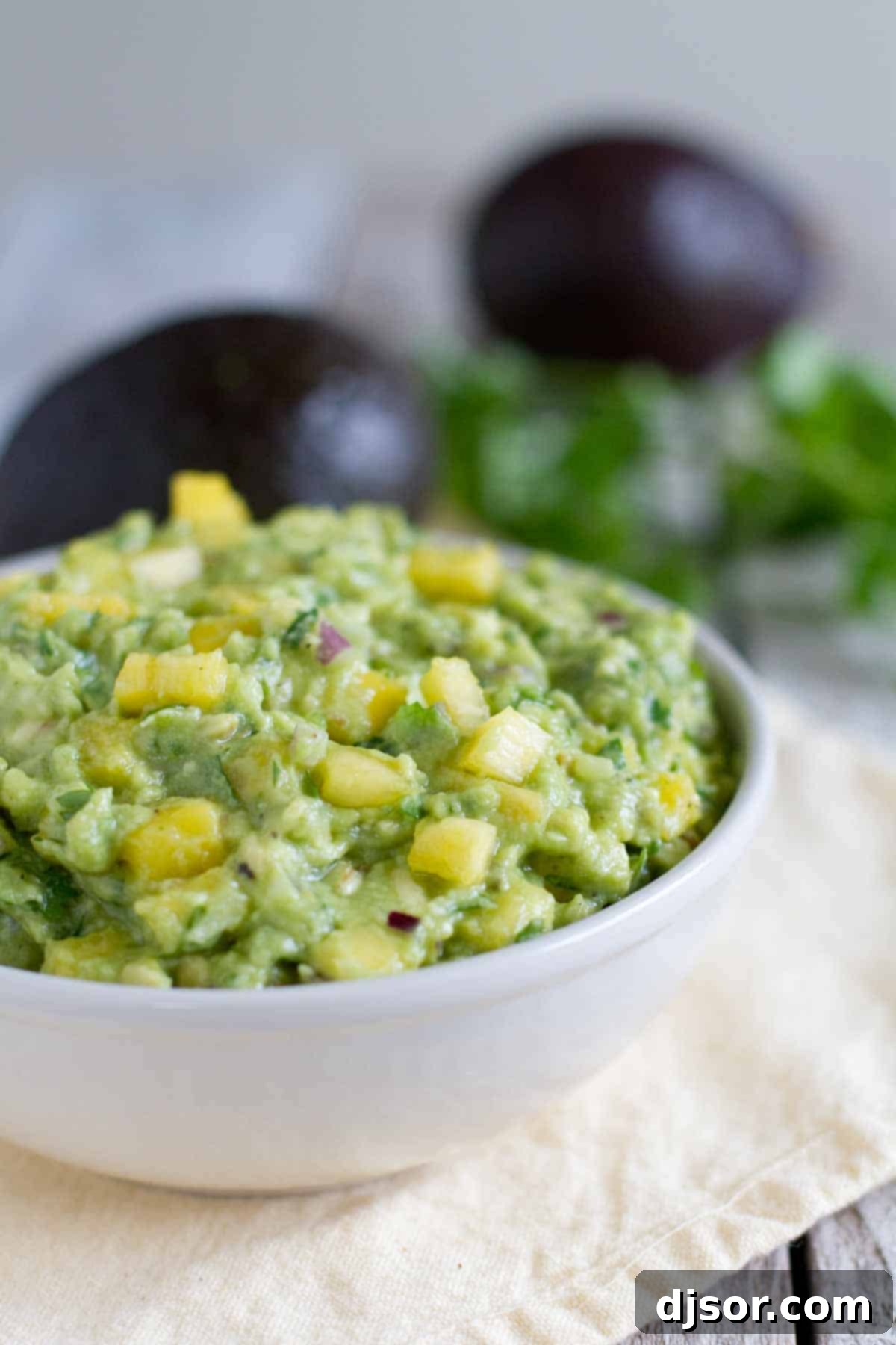 A taste of the tropics meets Mexico in this twist on guacamole in this Tropical Guacamole, loaded with Avocados from Mexico, Pineapple and Mango. Bowl of Tropical Guacamole topped with pineapple.