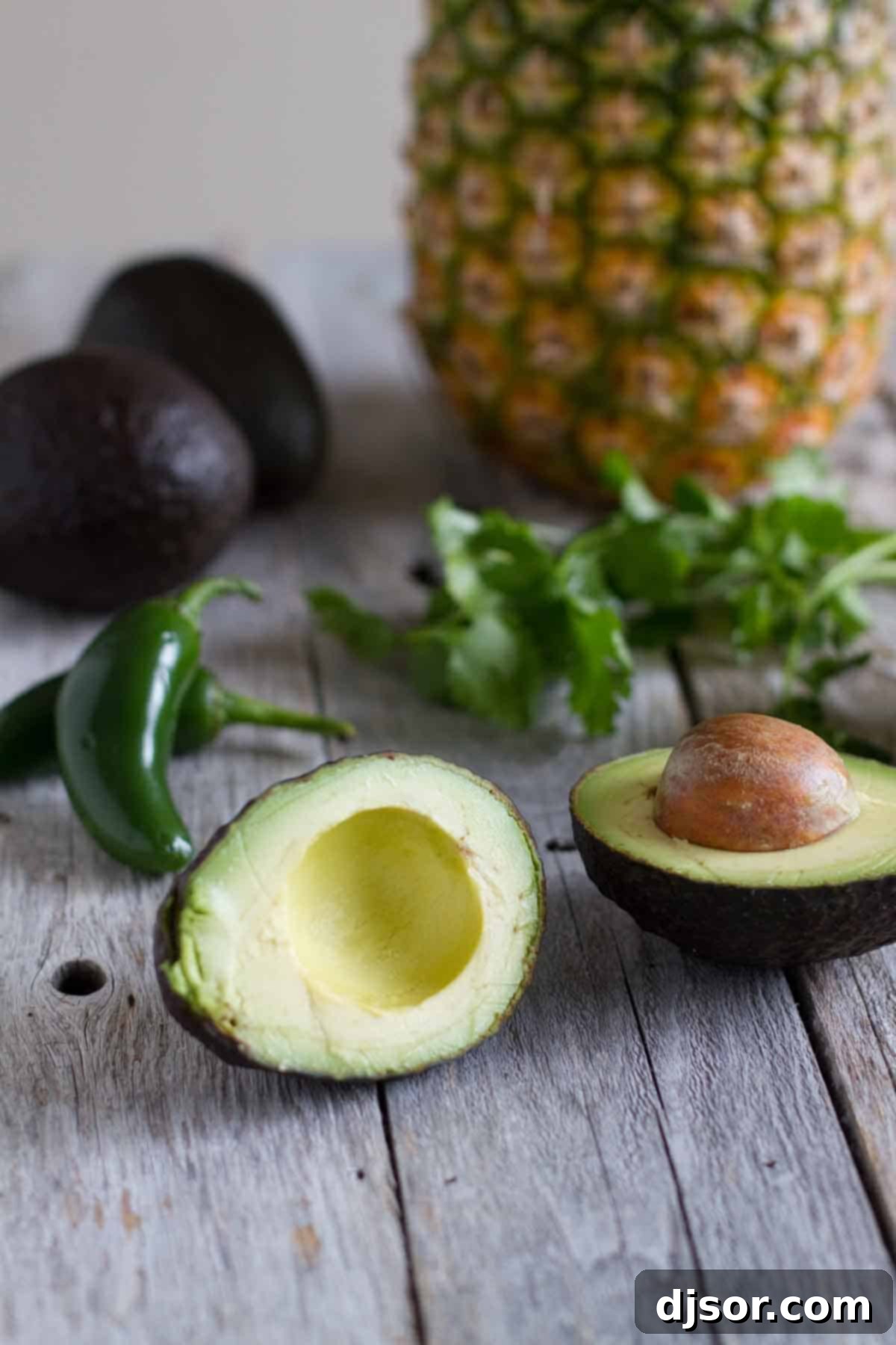 A taste of the tropics meets Mexico in this twist on guacamole in this Tropical Guacamole, loaded with Avocados from Mexico, Pineapple and Mango. Photo with pineapple, avocado, jalapeno and cilantro.
