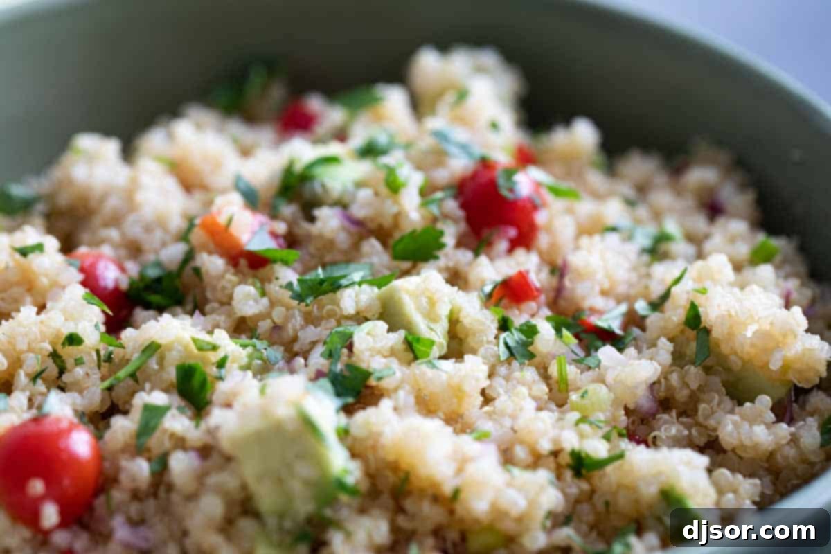 Delicious and colorful quinoa salad with fresh vegetables and a citrus dressing, served in a bowl.
