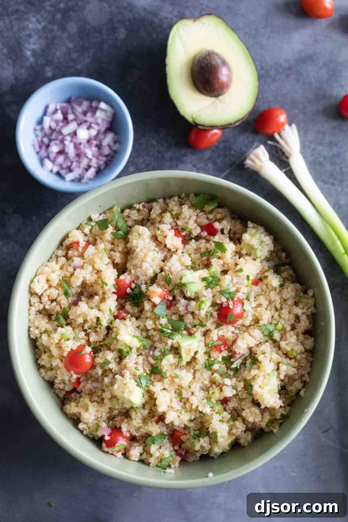 A bowl of freshly cooked and fluffed quinoa, ready to be mixed into a salad.