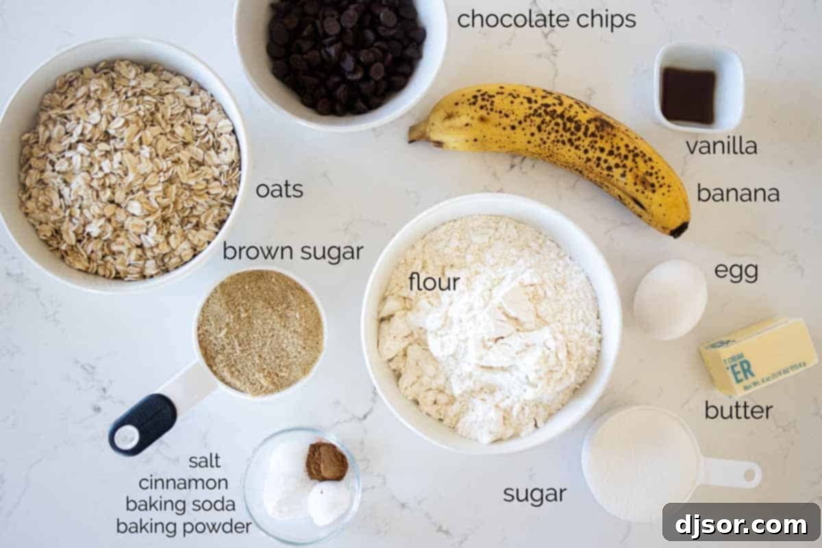Various ingredients for banana oatmeal chocolate chip cookies laid out on a kitchen counter, including flour, oats, bananas, butter, sugars, and chocolate chips.