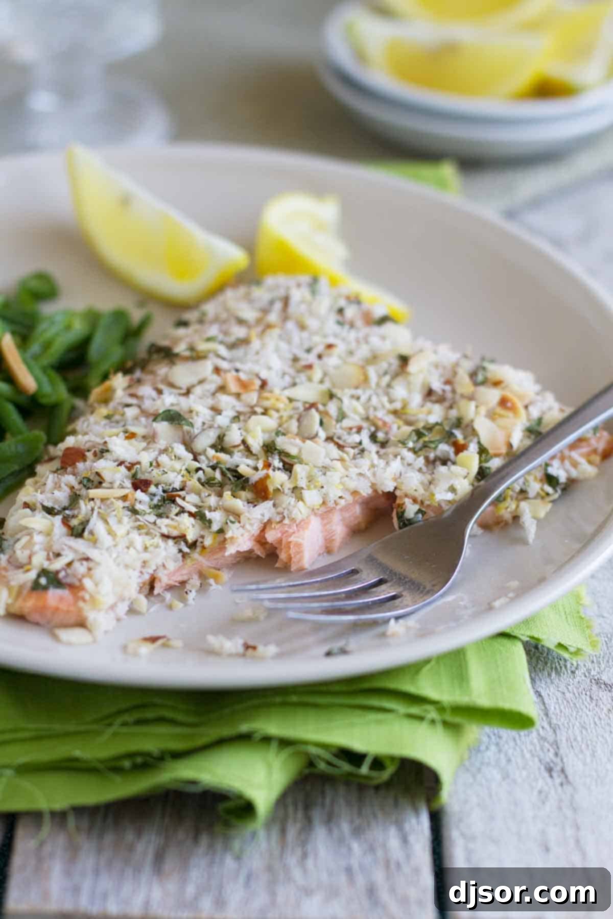Close-up of Almond Crusted Salmon on a plate, showing the crispy texture of the crust and the tender flaked salmon beneath.