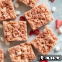 Pink Strawberry Crispy Treats 11 Strawberry Rice Krispie Treats cut into bars, with freeze dried strawberries and mini marshmallows.