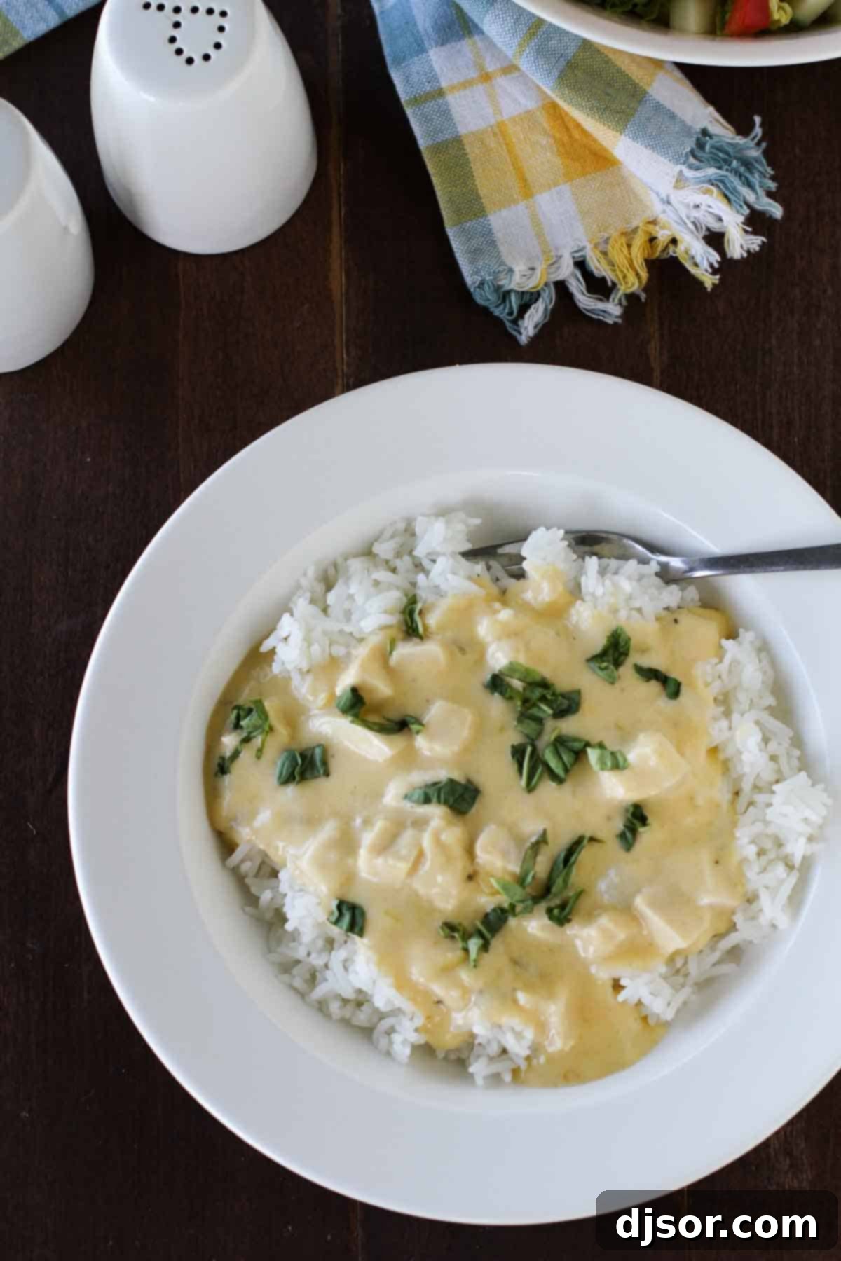 Overhead view of Cheesy Sour Cream Chicken, a perfect family meal. An overhead shot of a deep dish filled with creamy Cheesy Sour Cream Chicken, highlighting the rich sauce and tender chicken.