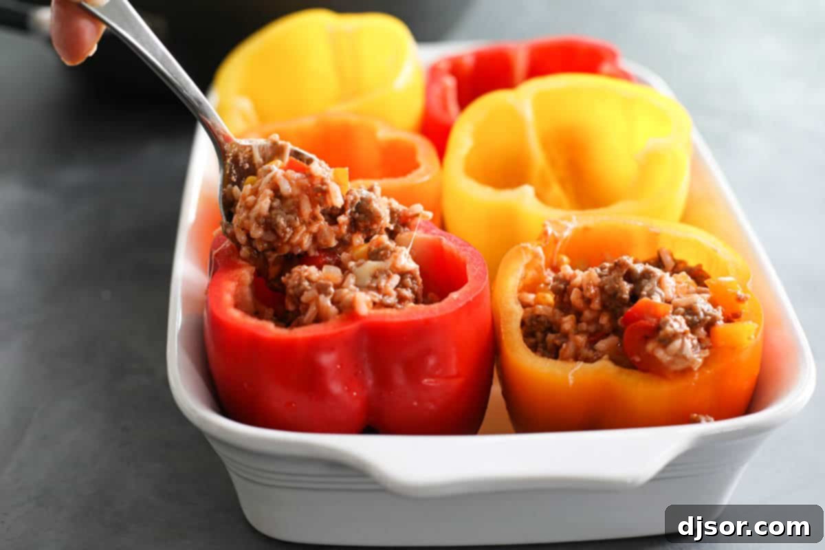A classic recipe, these Stuffed Bell Peppers are filled with ground beef, Italian sausage, rice, and vegetables. They are hearty and healthy dinner idea. filling bell peppers with meat mixture
