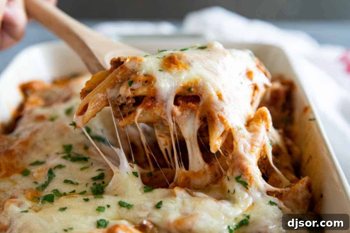 Pure comfort food, this Penne Pasta Bake recipe has a meaty, creamy sauce and lots and lots of cheese. It is perfect for a busy night, and is perfect for feeding a crowd. taking a scoop of penne pasta bake out of casserole dish