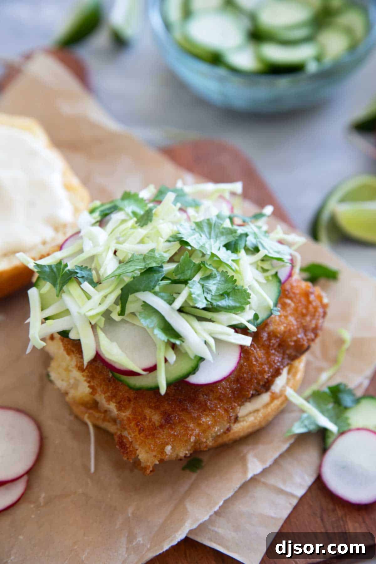 Crispy Fish Sandwich with the top taken off to show cabbage, radish, and cucumber toppings.