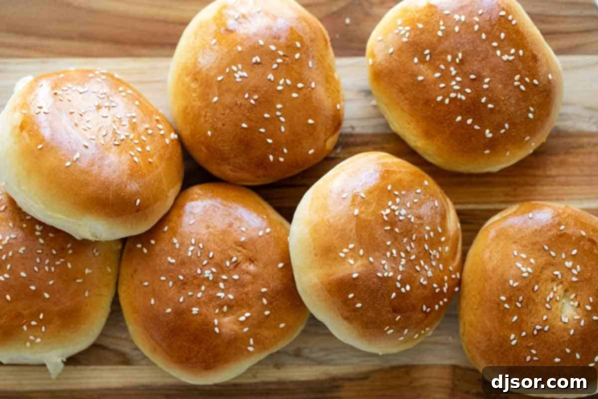 Homemade Hamburger Buns Recipe: Soft and Fluffy Bread for Your Next Burger A pile of golden-brown homemade hamburger buns stacked on a rustic wooden cutting board, ready to be filled with delicious burgers.