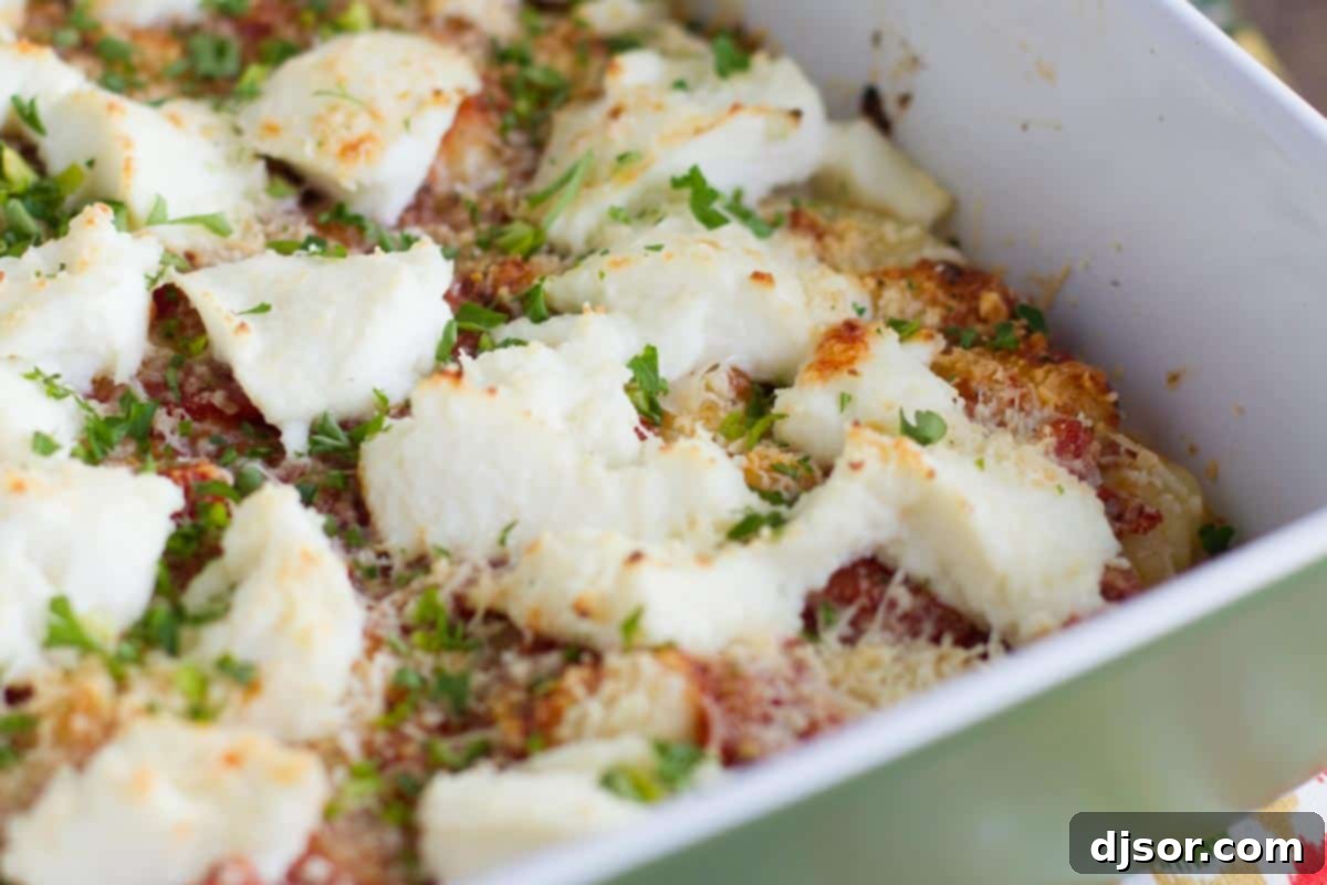 Dish of tender baked gnocchi generously topped with creamy ricotta and grated Parmesan cheese, ready for a quick weeknight dinner.