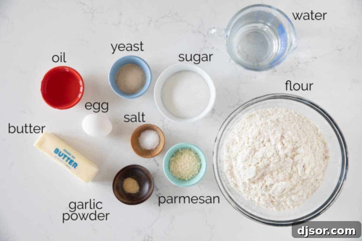 A collection of fresh ingredients laid out, ready for making homemade breadsticks, including flour, yeast, butter, and Parmesan cheese.