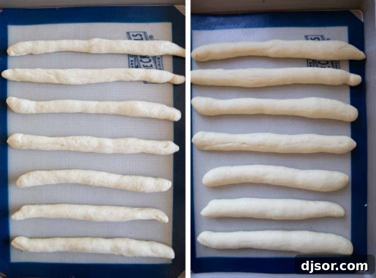 Soft breadstick dough, perfectly risen and expanded, resting in a bowl covered with plastic wrap.