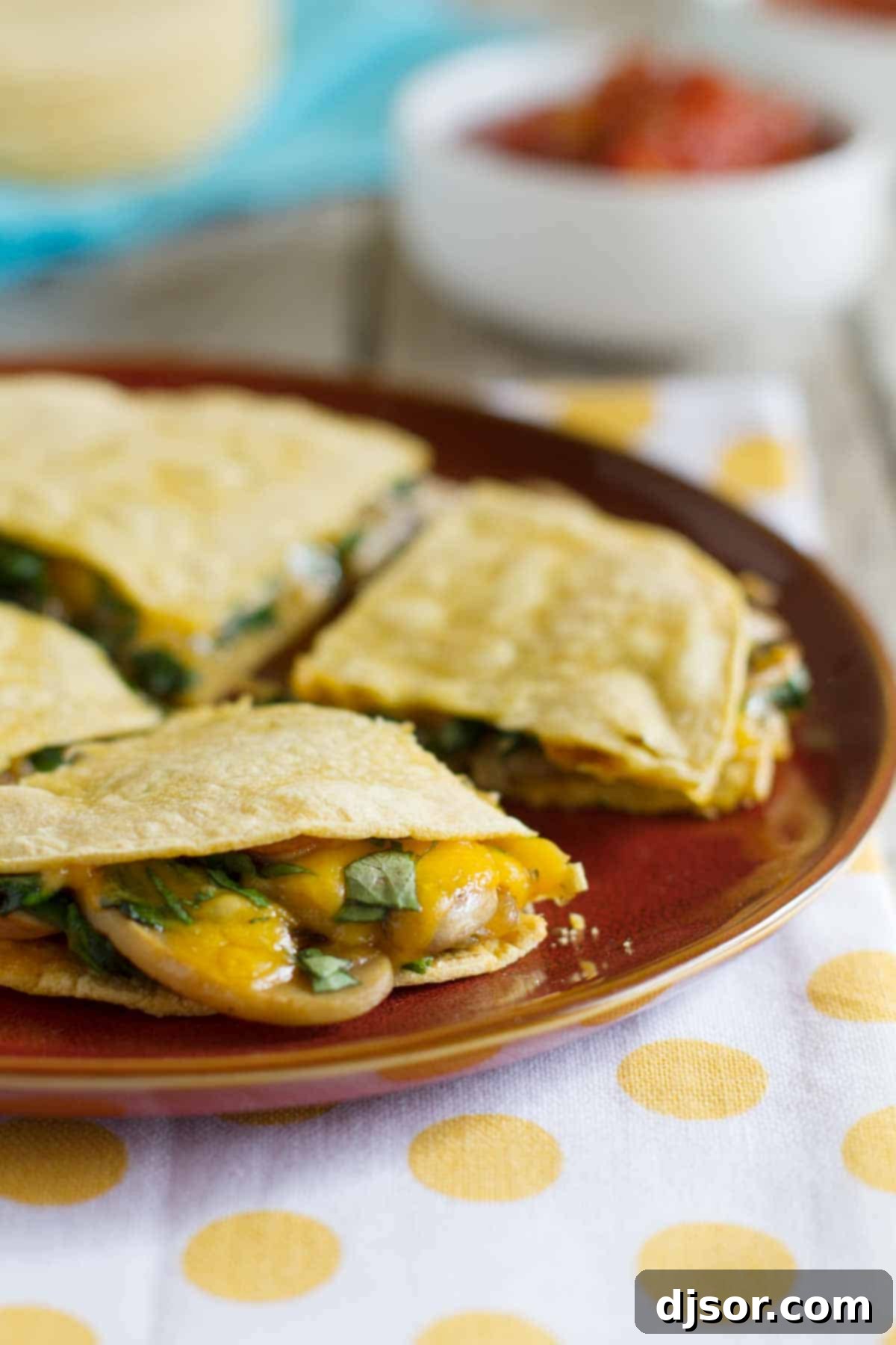 Hearty and filling, you’ll never miss the meat in these vegetarian Mushroom Spinach Quesadillas! Delicious Mushroom Spinach Quesadillas on a plate, with melted cheese and sautéed mushrooms visible, ready to be served as a healthy, vegetarian meal.
