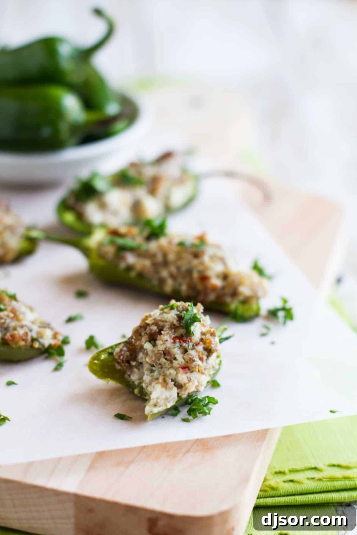 These Sausage Stuffed Jalapeños are the perfect appetizer - jalapeño halves that are filled with a sausage and cheese mixture for a cheesy and spicy appetizer bite. Perfect for game day or for company. Cream Cheese Stuffed Jalapenos with a bite taken from one.