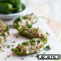 Sausage Stuffed Jalapeno Poppers 2 Stuffed Jalapenos with Sausage and Cream Cheese on parchment paper