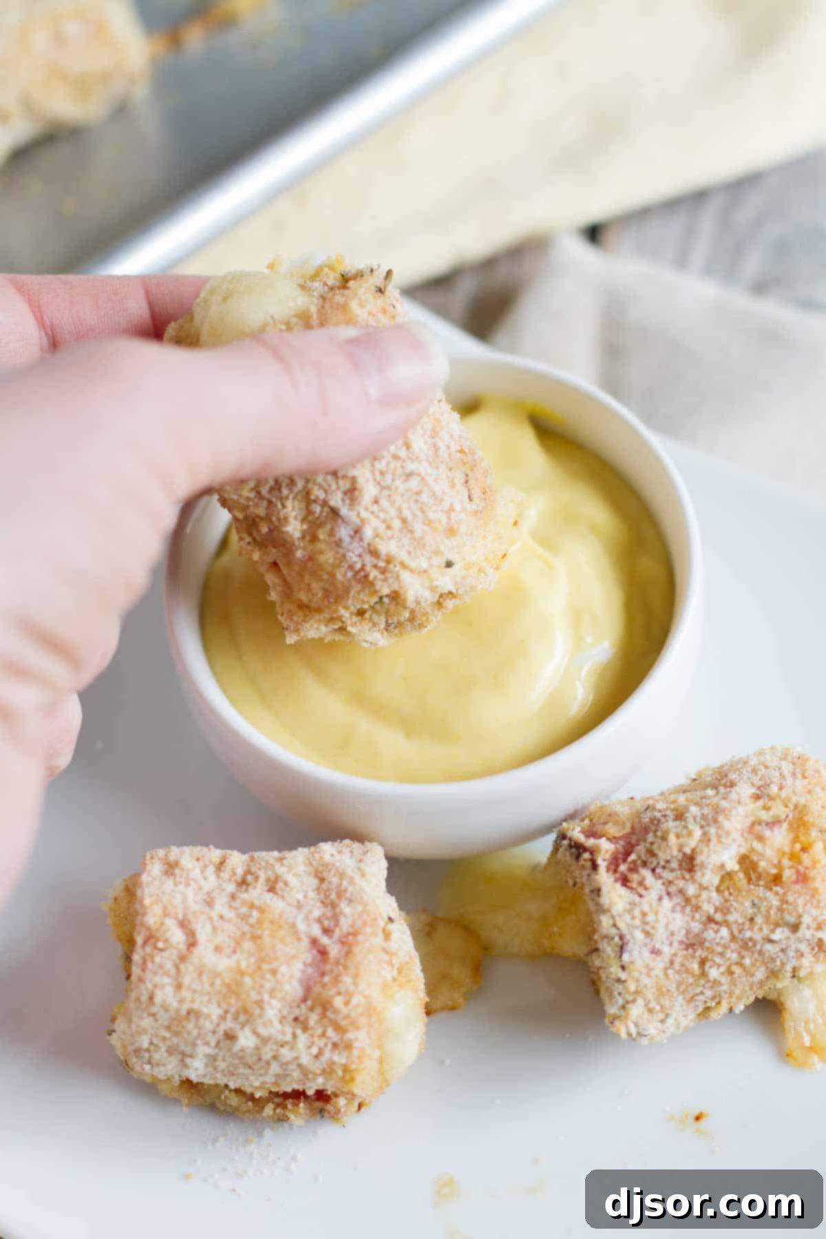 dipping chicken cordon bleu nuggets into honey mustard sauce