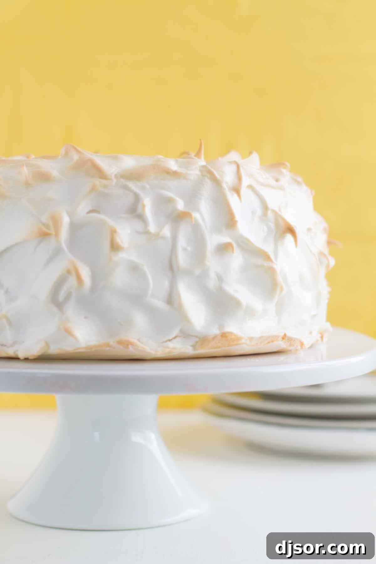 Celestial Lemon Meringue Dream 2 full Lemon Meringue Angel Cake on a cake stand with yellow in the background
