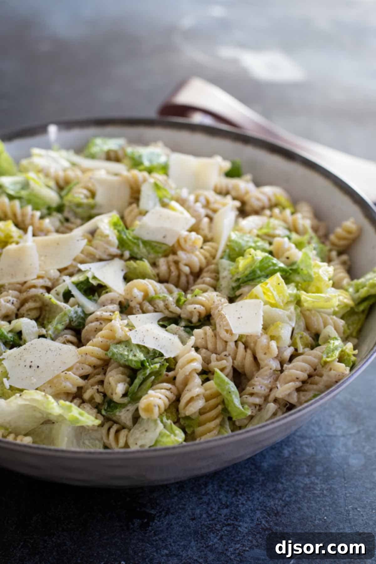 Caesar Salad with Pasta with Homemade Caesar Dressing, featuring spiral pasta and crisp romaine lettuce.
