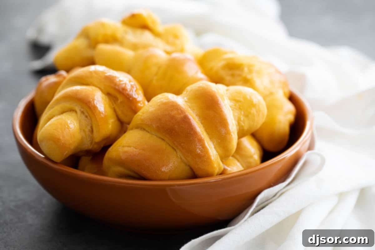 Soft and fluffy and slightly sweet, these Sweet Potato Buttermilk Crescent Rolls are perfect for a holiday. These homemade crescent rolls are so much better than store bought! bowl of sweet potato buttermilk crescent rolls