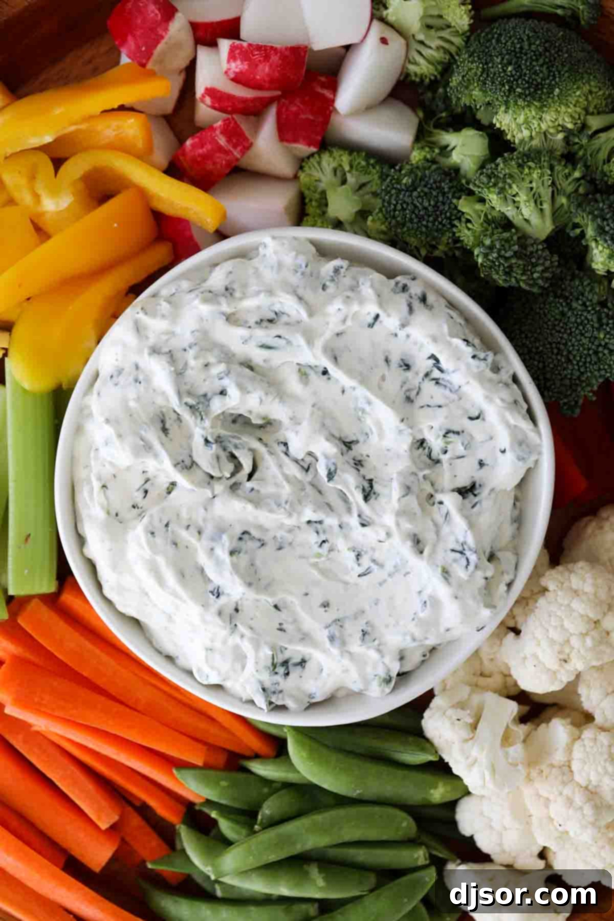 Close up of creamy spinach dip in a white bowl with a spoon