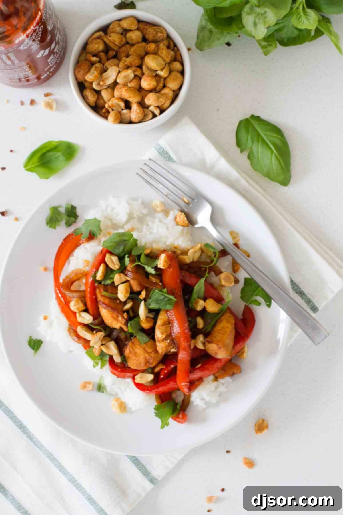 Thai Chili Chicken 3 Close-up of Spicy Thai Chicken in a pan, showcasing colorful peppers, tender chicken, and fresh basil leaves.