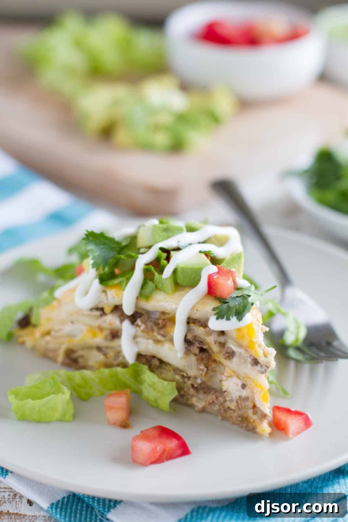 slice of taco tortilla stack on a plate, showcasing layers of beef, cheese, and tortilla