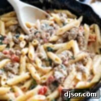 Tuscan pasta with sausage in a cast iron skillet.