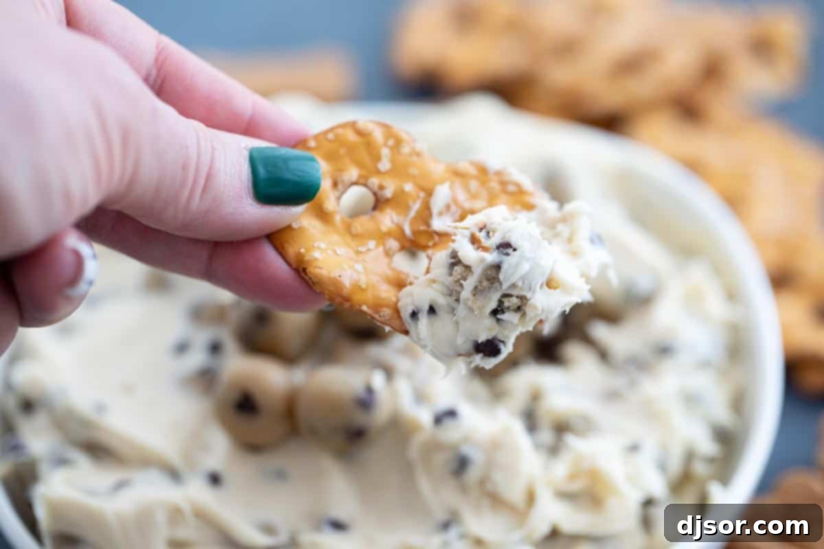 This Chocolate Chip Cookie Dough Dip is a sweet cream cheese dip that is loaded with balls of egg-free cookie dough. Serve with graham crackers, vanilla wafers, or pretzel crisps. pretzel crisp with chocolate chip cookie dough dip