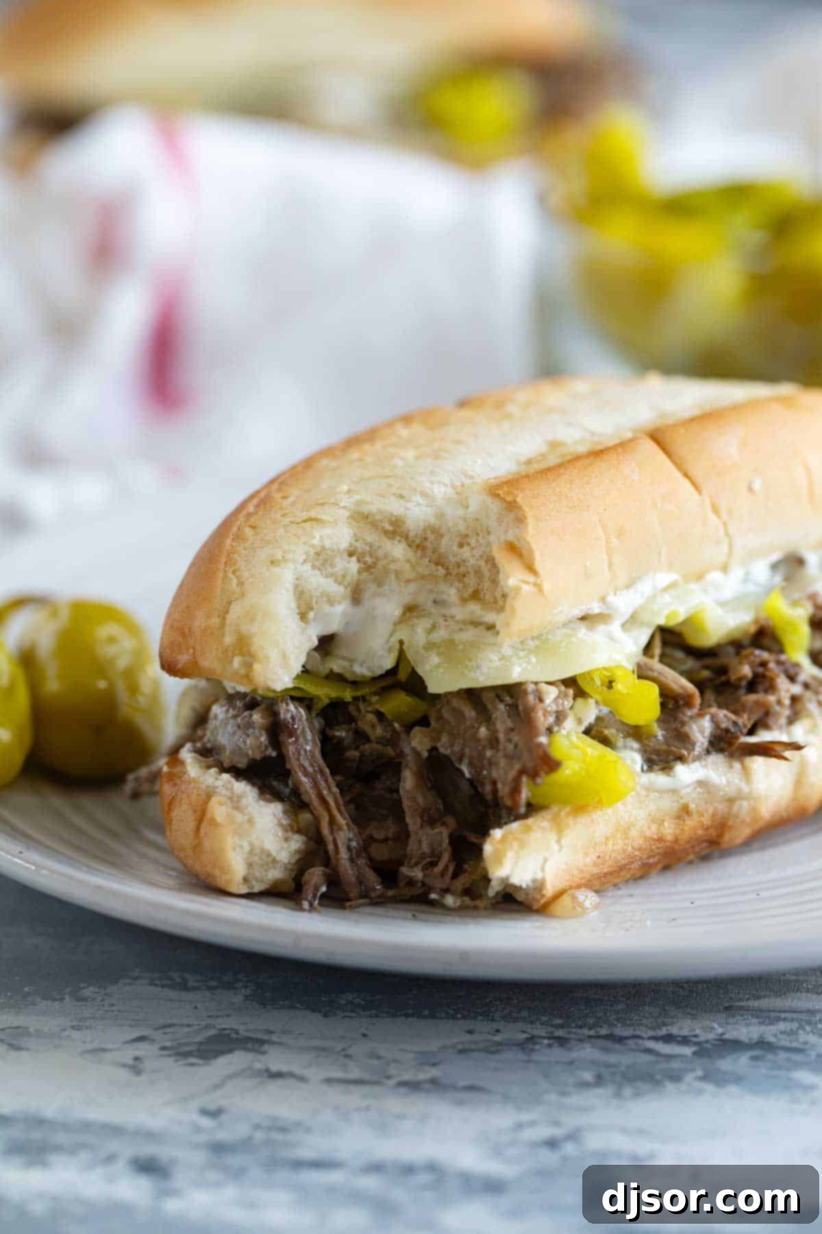 Chicago's Iconic Italian Beef 8 A close-up of an Italian Beef Sandwich with a bite taken, showing the tender beef, cheese, and sauce.