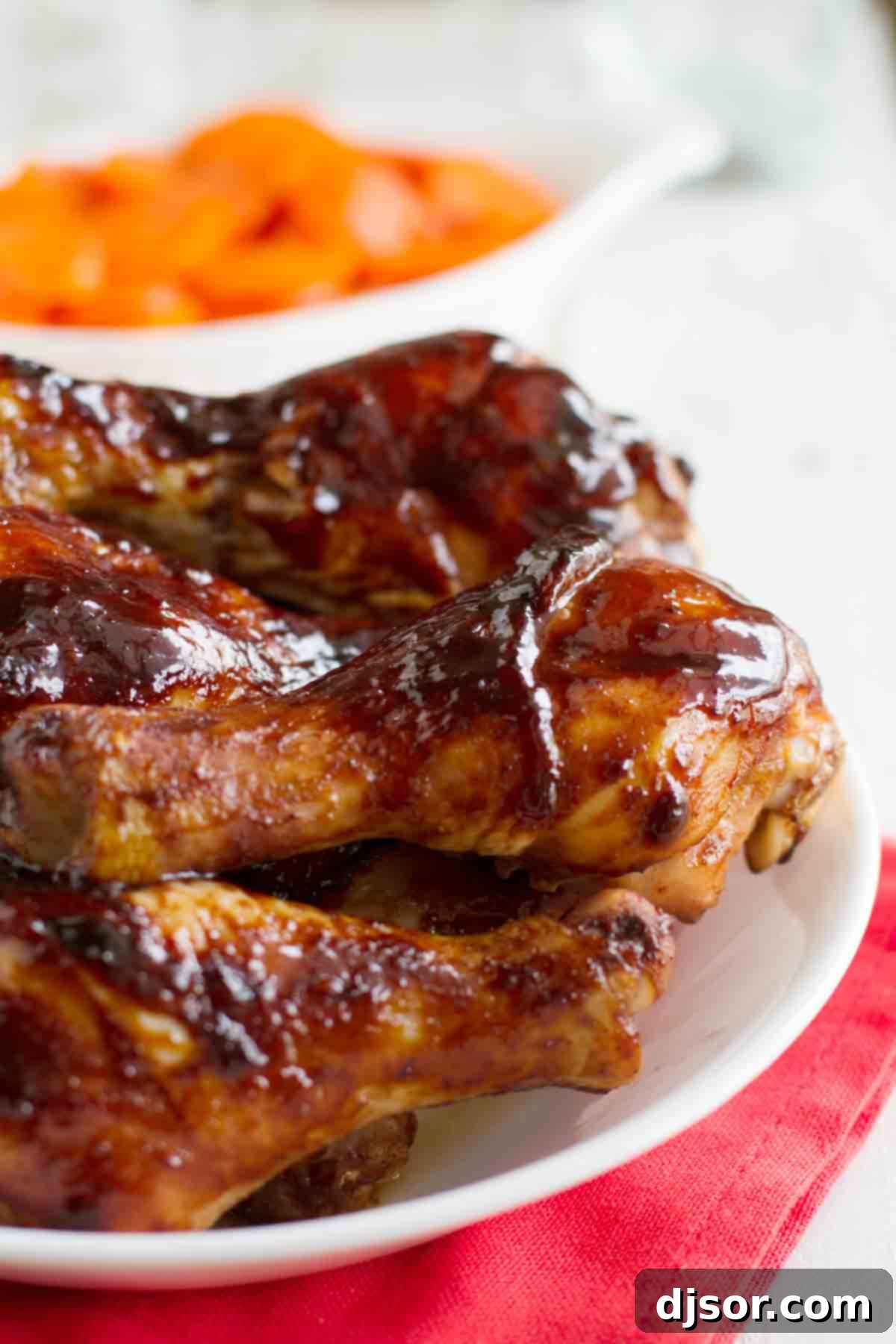 Chicken drumsticks are glazed and baked with an easy, sweet hoisin glaze in this recipe for Hoisin Glazed Chicken. plate with hoisin glazed chicken drumsticks