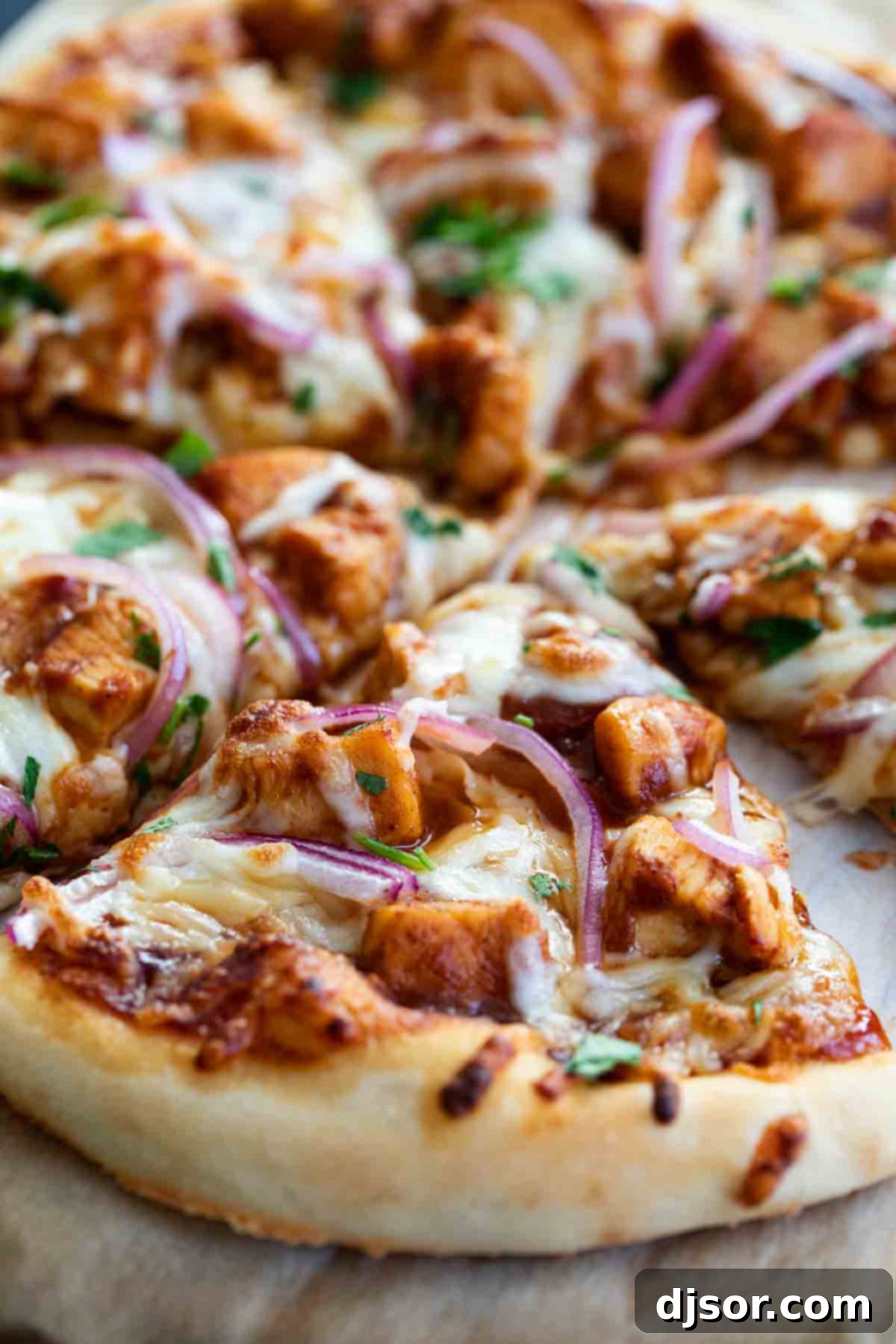 Delicious BBQ Chicken Pizza topped with BBQ sauce, tender chicken, red onions, and fresh cilantro, sliced and ready to serve