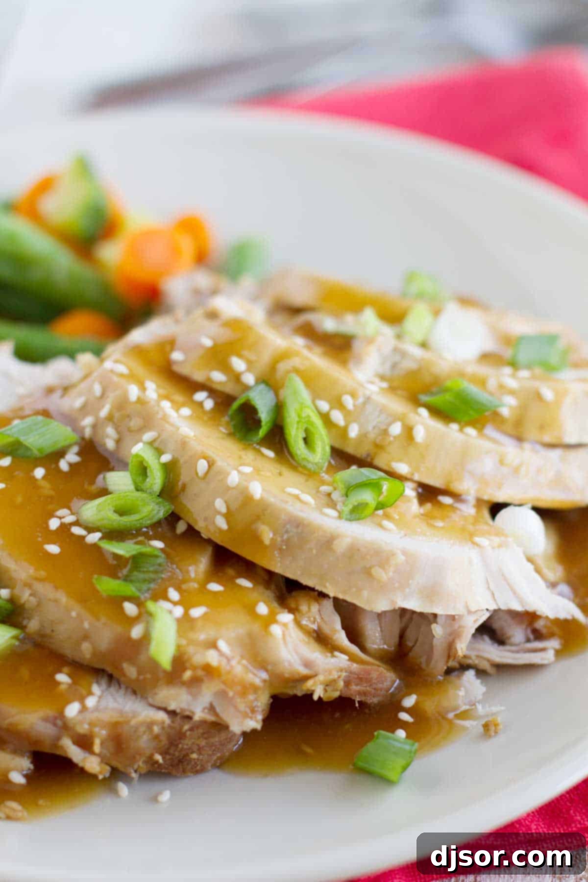 Slow cooker sesame pork sliced and served on a plate.