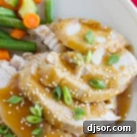 Slow Cooker Sesame Pork topped with sauce, green onions, and sesame seeds.