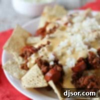 Chili Dog Nachos recipe image with hot dog filled chili and cheese sauce.