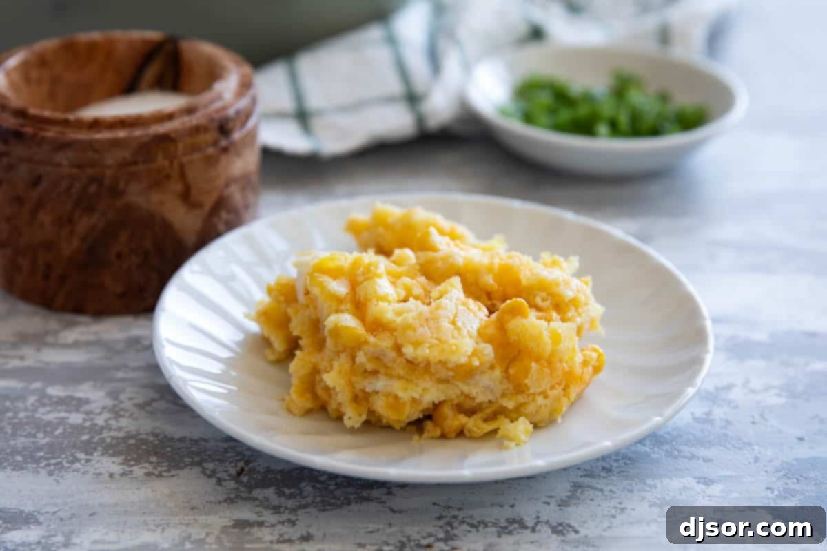 Serving of corn casserole on a small white plate.