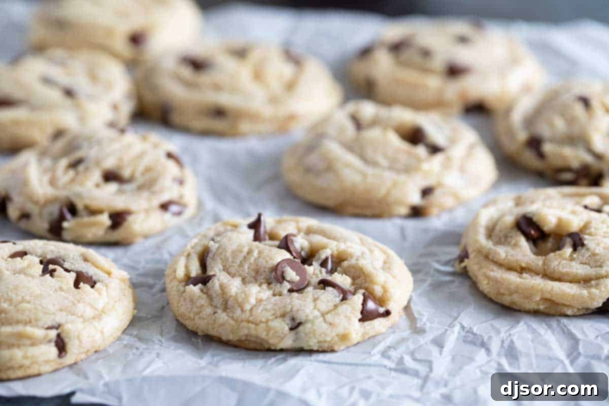 The ultimate soft and chewy Toll House Cookie recipe. Perfectly baked Toll House Chocolate Chip Cookies on parchment paper, showcasing their soft centers and crispy edges.