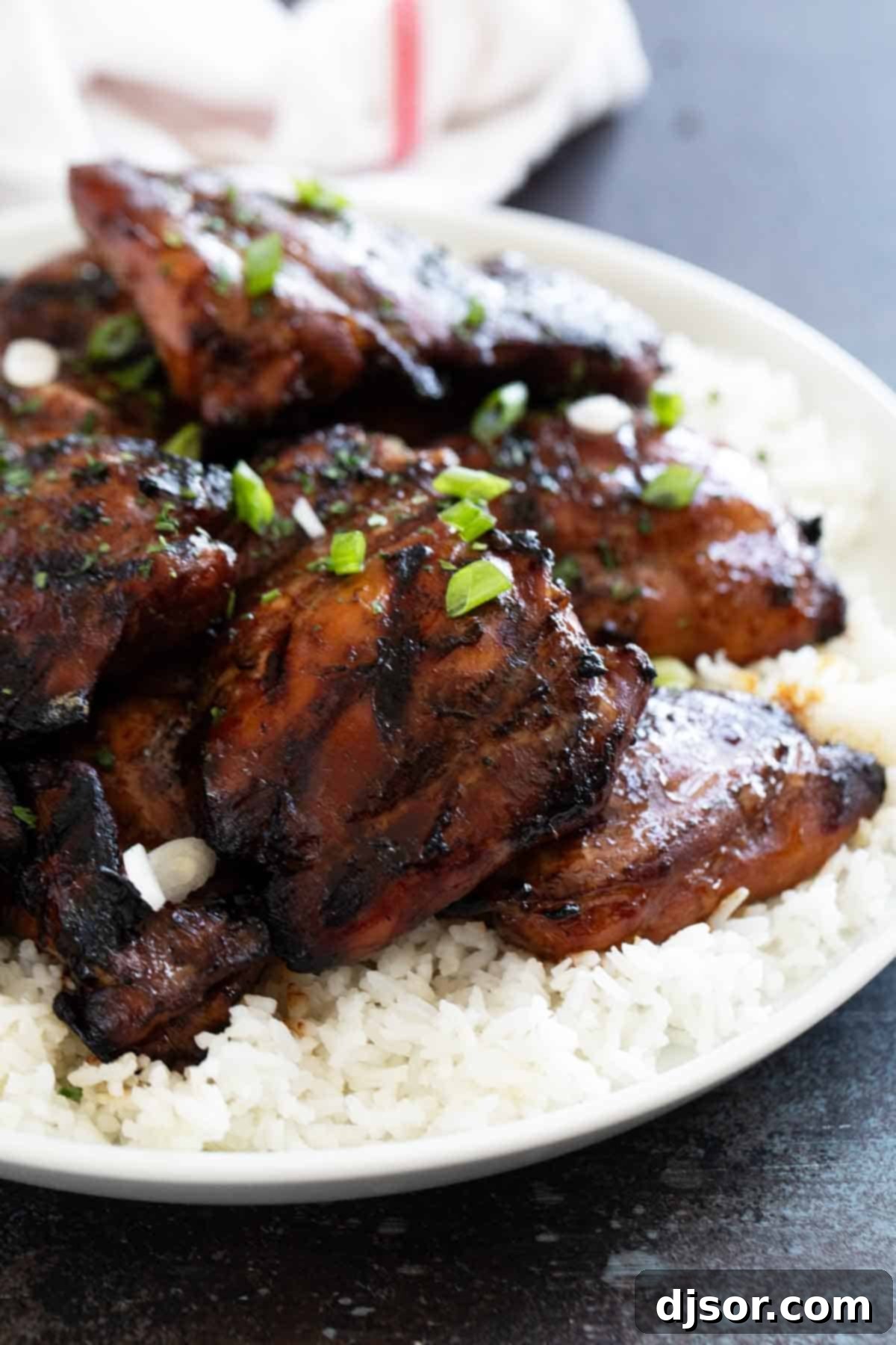Sticky Honey Soy Glazed Chicken 2 Flavorful Honey Soy Chicken garnished with fresh parsley and vibrant green onions, ready to be served.