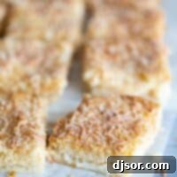 Four Ingredient Coconut Bliss Bars 2 cut coconut bars on a piece of parchment paper