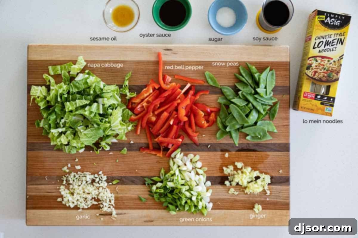 Fresh ingredients laid out on a wooden cutting board, ready for making homemade Lo Mein, including vegetables, noodles, and sauce components.
