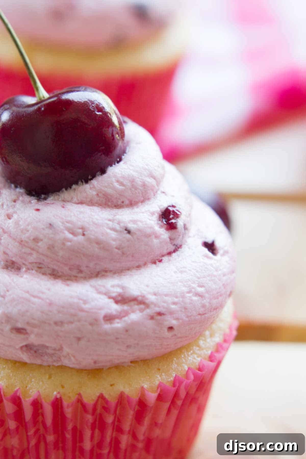 A close-up shot of the vibrant pink fresh cherry frosting, showcasing its smooth yet chunky texture.