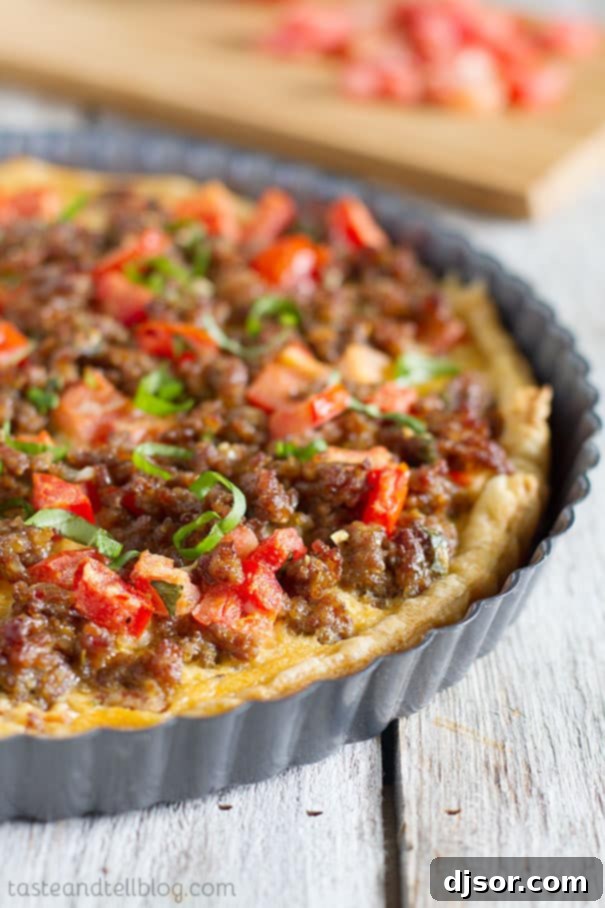 Savory Italian Tart - A golden puff pastry crust topped with a rich filling of Italian sausage, diced tomatoes, scrambled eggs, and melted cheese, ready for serving.