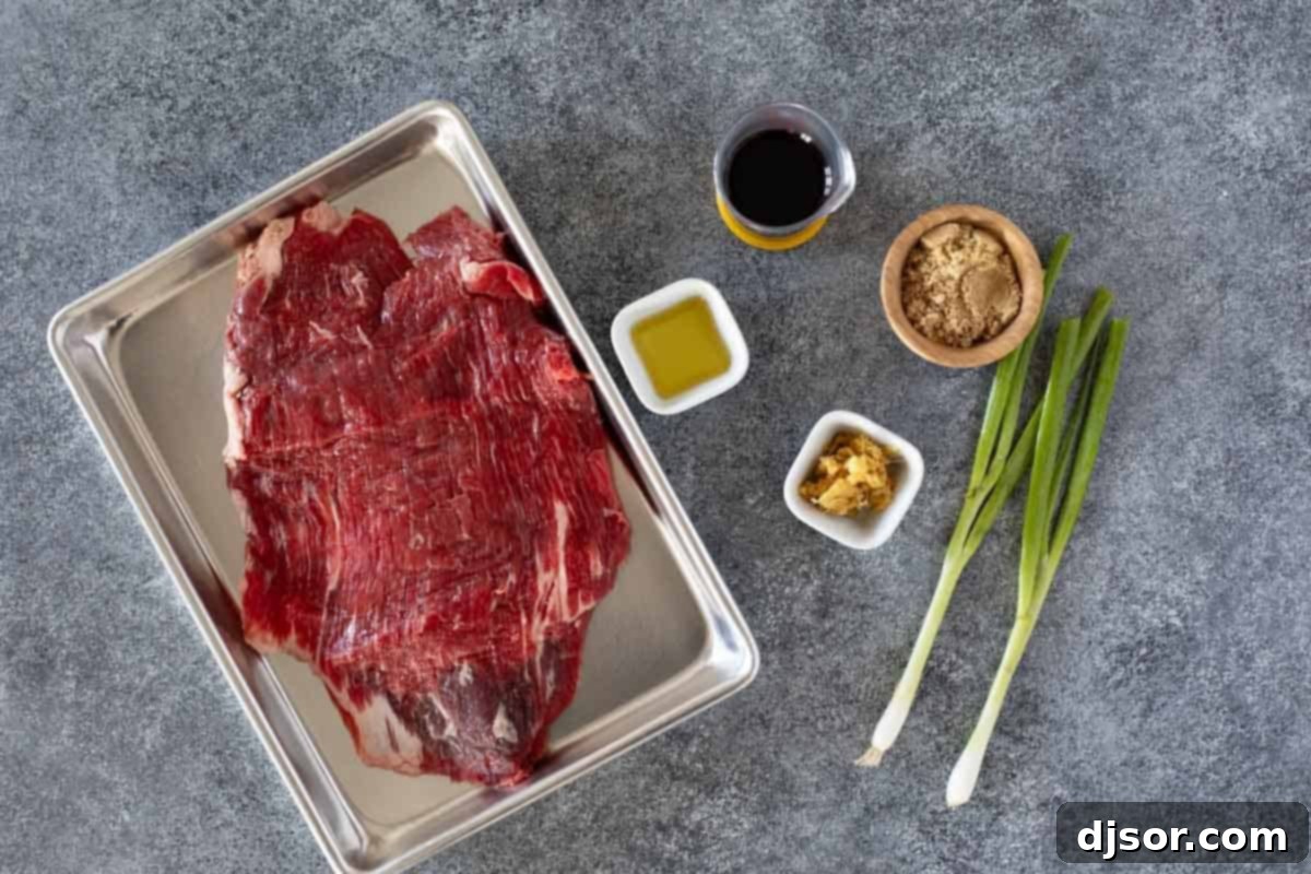 A vibrant selection of fresh ingredients laid out for Korean Flank Steak, including soy sauce, brown sugar, sesame oil, fresh ginger, garlic, and a piece of raw flank steak.