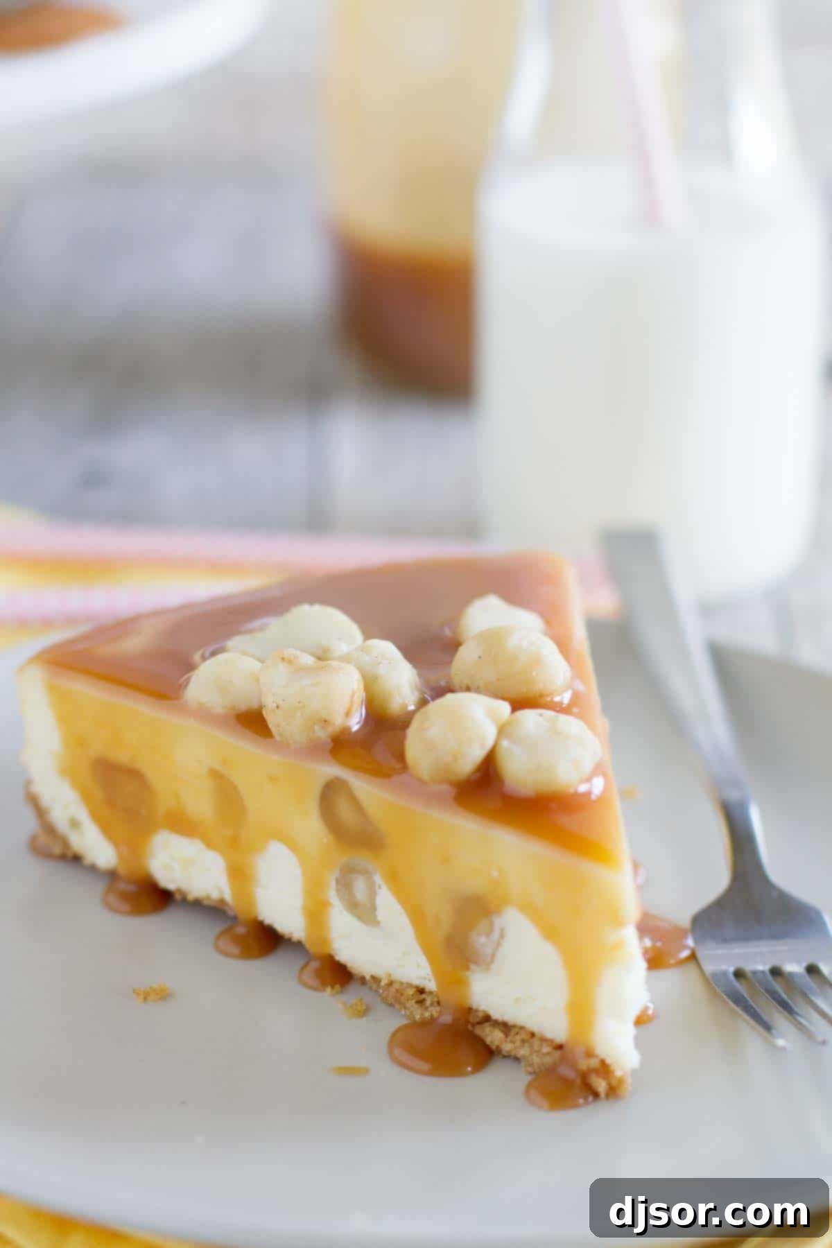 White Chocolate Cheesecake with Macadamia Nuts and Caramel - Creamy white chocolate cheesecake has macadamia nuts throughout, with a homemade caramel sauce poured over the top. A perfect slice of white chocolate cheesecake, generously topped with glistening homemade caramel sauce and chopped macadamia nuts, ready to be enjoyed.